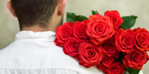 Muž daruje rudé růže jako symbol lásky