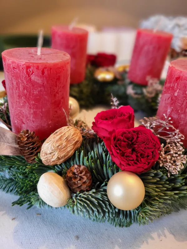 Detail modrozeleného jehličí jedle nobilis na adventním věnci s růží, šiškou a ořechem