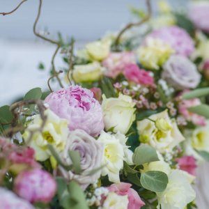 Výzdoba svatebního stolu z růží, pivoněk, eustomy a eucalyptu