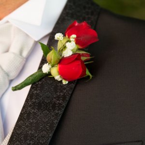 Svatební korsáž pro ženicha z červených růží a gypsophily