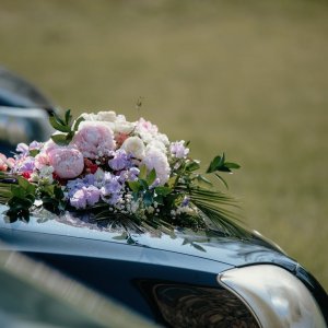 Svatební květiny na auto z růží, pivoněk, gypsophily a eucalyptu