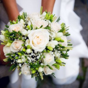 Svatební kytice pro nevěstu z bílých růží, frézií a gypsophily
