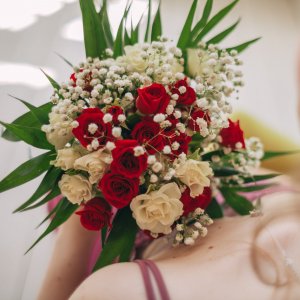 Svatební kytice pro nevěstu z bílých a červených růží a gypsophily